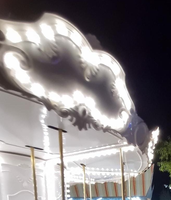 Işıklarla süslü beyaz atlıkarıncanın tavanı, gece