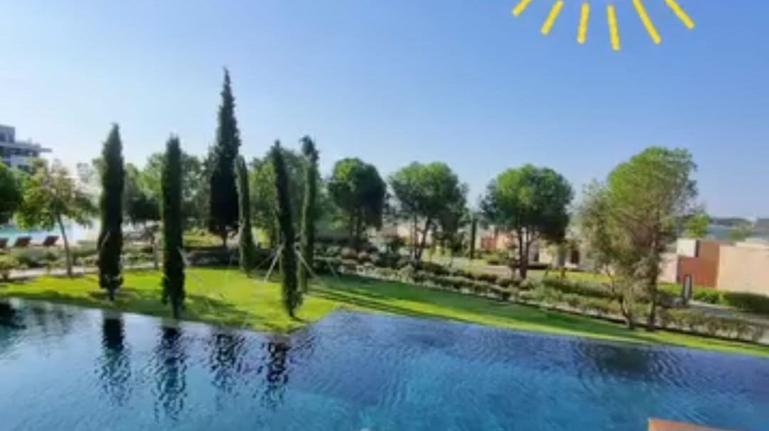 Odanın önündeki havuz, servi ağaçları ve arkada göl manzarası