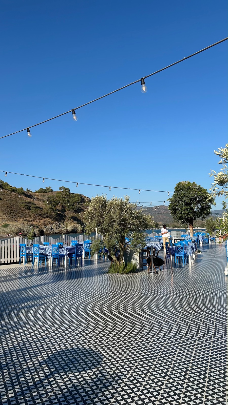 Mavi sandalyeli, deniz manzaralı à la carte restoran terası, desenli zemin